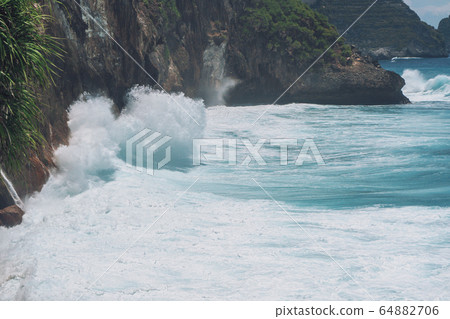 Photo of large waves crashing into large rocks on 64882706
