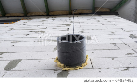 A insulated ventilation pipe comes out of the wall of the house A insulated ventilation pipe comes out of the wall of the house 64884492