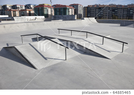 Sloped metal rails for grind tricks in an empty 64885465