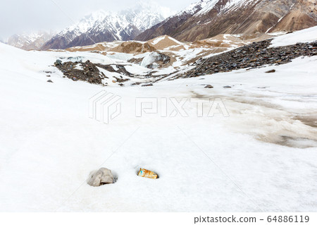 Garbage scattered over snowy mountain. Let's save the planet and recycle the excess garbage. Pollution Concept Garbage scattered over snowy mountain. Let's save the planet and recycle the excess garbage. Pollution Concept 64886119