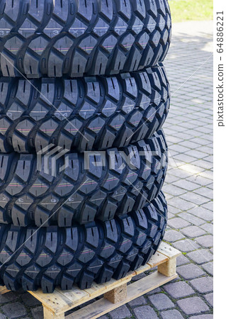 a set of new mud and terrain tires on a wooden 64886221