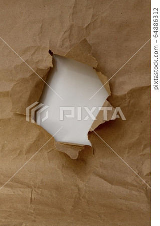 Vertical shot frame in the form of a torn hole of brown paper with a white inner layer of the window. 64886312