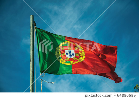 Portuguese flag fluttering in the blue sky 64886689