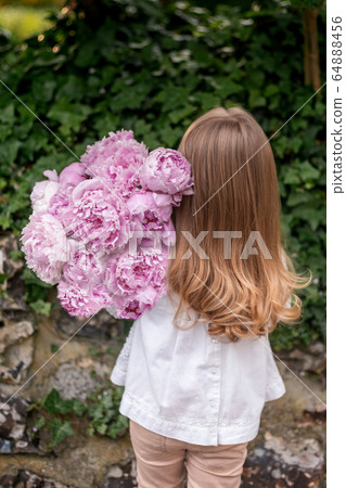 Girl holding a fresh pink peonies bouquet Girl holding a fresh pink peonies bouquet 64888456