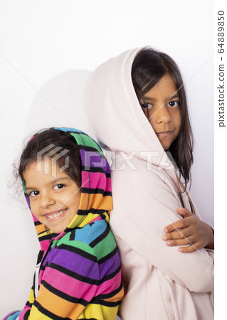 Portrait of little sisters wearing hooded sweater 64889850