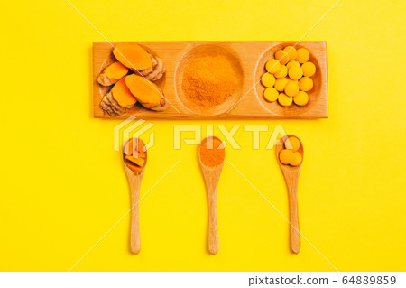 Turmeric in different conditions: fresh, dry root, pills, powder and cut plant. 64889859