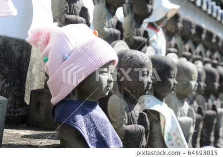A Jizo with a cute Jizo wearing a hat on a sunny day A Jizo with a cute Jizo wearing a hat on a sunny day 64893015