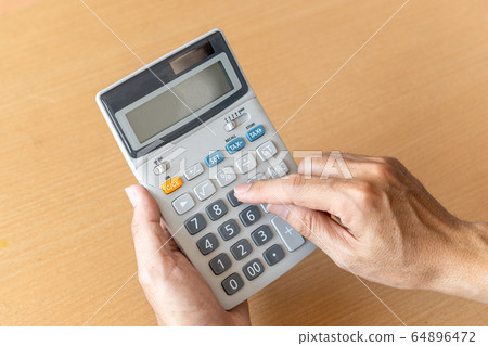 Man hands holding and using a calculator 64896472