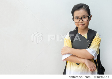 Asian girl elementary school with book and bag. 64896634