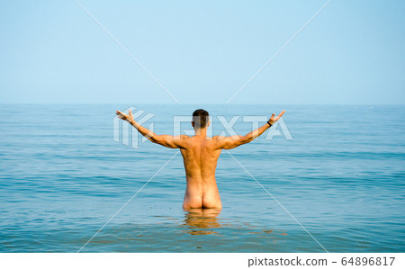 nude man in blue water - Stock Photo 64896817