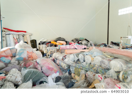 Stack of fabric raw material. Clothing in plastic 64903010