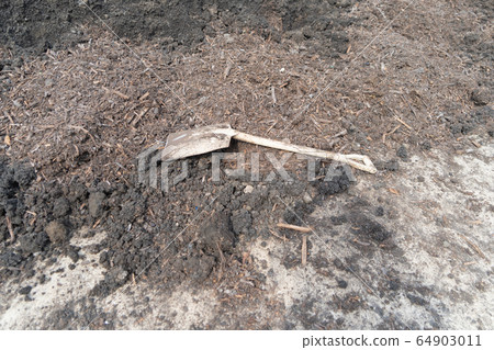 A hoe and soil fertile ground surface. Close up of 64903011