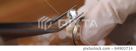 Jeweller installing gemstone 64903714