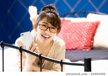 女臥室床智能手機房間穿微笑 女臥室床智能手機房間穿微笑 64904498