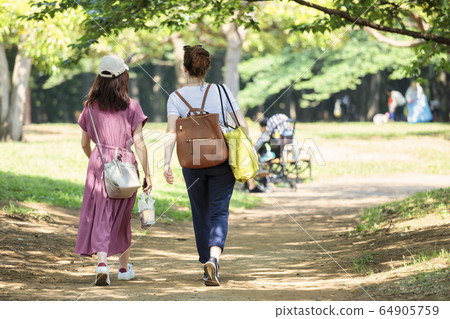 Duo of girls walking in the park 64905759