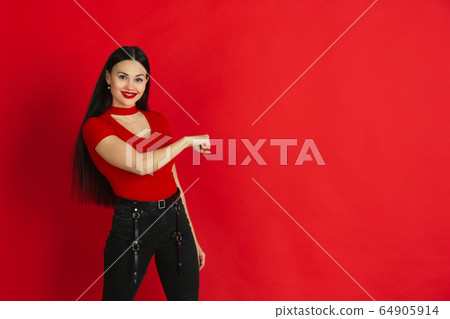 Caucasian young woman's monochrome portrait on red studio background, emotional and expressive Caucasian young woman's monochrome portrait on red studio background, emotional and expressive 64905914