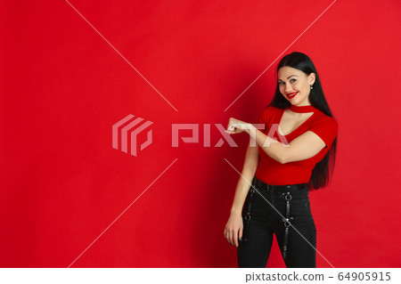 Caucasian young woman's monochrome portrait on red studio background, emotional and expressive Caucasian young woman's monochrome portrait on red studio background, emotional and expressive 64905915