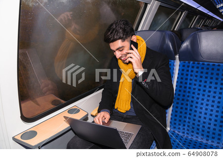 Businessman calls on phone and works on laptop 64908078