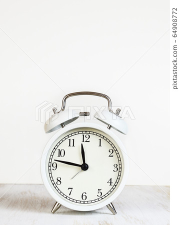 White alarm clock on table White alarm clock on table 64908772
