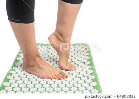 Female foot on an acupuncture rug. Acupuncture, massage. Alternative medicine. Female foot on an acupuncture rug. Acupuncture, massage. Alternative medicine. 64908832