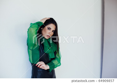 Beautiful fashionable oriental brunette woman in black green dress 64909857