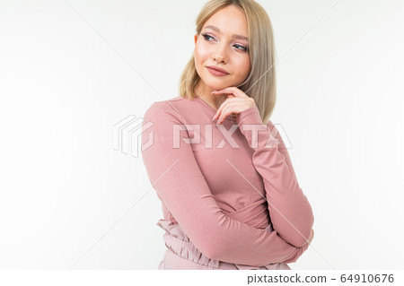 cute blond girl with a short haircut keeps a secret on a white studio background with copy space cute blond girl with a short haircut keeps a secret on a white studio background with copy space 64910676