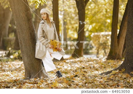Elegant and stylish girl in a autumn park Elegant and stylish girl in a autumn park 64913050