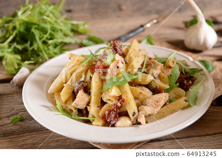 Penne pasta with chicken, dried tomatoes and 64913245