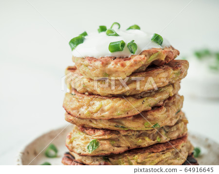 Traditional zucchini fritters, served sour cream 64916645