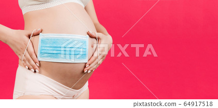 banner of medical mask on the belly of a pregnant 64917518