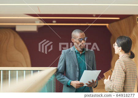 Business partners talking at the corridor Business partners talking at the corridor 64918277