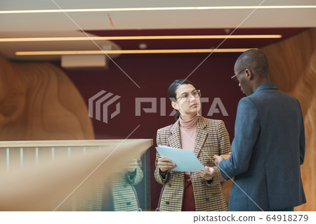 Businesswoman consulting with businessman at office Businesswoman consulting with businessman at office 64918279