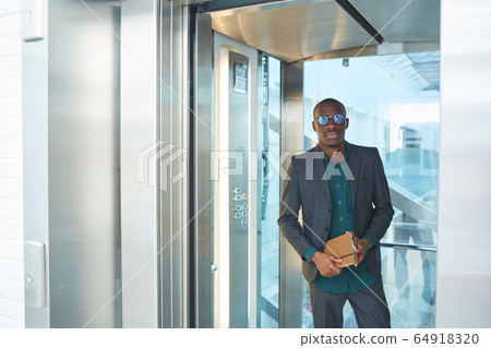 Businessman standing in the elevator Businessman standing in the elevator 64918320