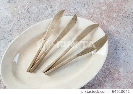 Old bronze knives on vintage ooval dish Old bronze knives on vintage ooval dish 64918641