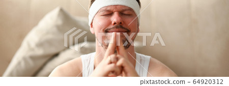 Man during self-isolation after sports meditates Man during self-isolation after sports meditates 64920312