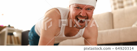 Man at home on carpet does an exercise plank Man at home on carpet does an exercise plank 64920314