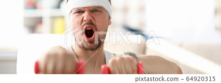 Guy fulfills strokes with dumbbells in his hands Guy fulfills strokes with dumbbells in his hands 64920315