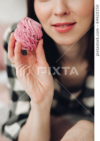 Attractive woman cook marshmallows and eats them 64920350