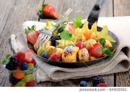 Delicious Austrian Kaiserschmarren served with fresh colorful fruit  64920561