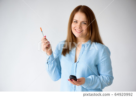 Diabetic patient measuring glucose level blood test using glucometer and small drop of blood 64920992