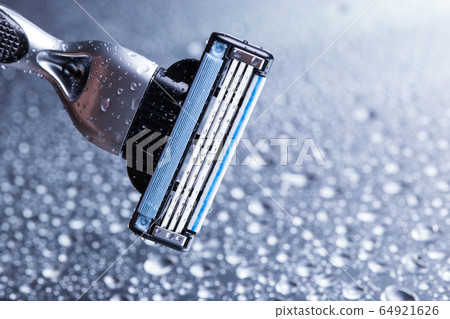 Razor close-up with water drops on a gray background. 64921626