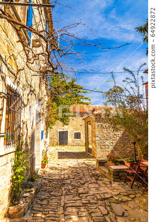 Narrow stone street with ancient houses. Narrow stone street with ancient houses. 64922872