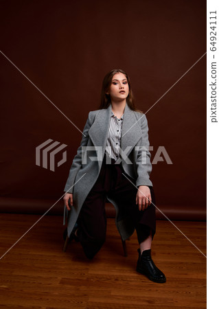Independent young woman posing in the photostudio. 64924111