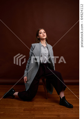 Independent young woman posing in the photostudio. Independent young woman posing in the photostudio. 64924112