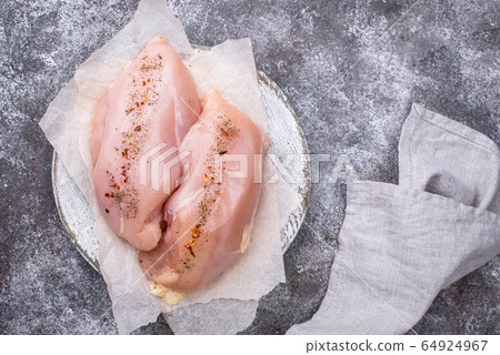 Raw chicken fillet on cutting board Raw chicken fillet on cutting board 64924967