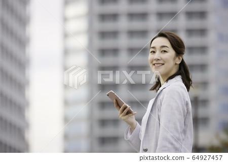 女性商務戶外智能手機的微笑 女性商務戶外智能手機的微笑 64927457