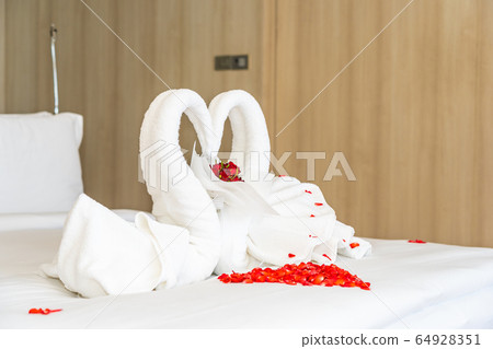 Swan towel on bed with red rose flower decoration interior Swan towel on bed with red rose flower decoration interior 64928351
