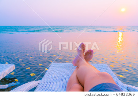 Selective focus point on leg around outdoor swimming pool in hotel resort at sunset or sunrise time Selective focus point on leg around outdoor swimming pool in hotel resort at sunset or sunrise time 64928369