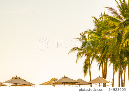 Beautiful tropical nature umbrella chair with palm tree around beach sea ocean at sunset or sunrise Beautiful tropical nature umbrella chair with palm tree around beach sea ocean at sunset or sunrise 64928603