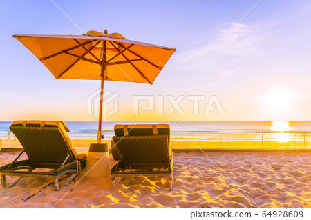 Beautiful tropical nature umbrella chair with palm tree around beach sea ocean at sunset or sunrise Beautiful tropical nature umbrella chair with palm tree around beach sea ocean at sunset or sunrise 64928609